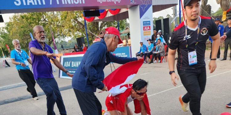 Hendro, penyumbang medali emas ke 8 hari ini (6/5) seusai menyelesaikan finish disambut Manager Pelatnas Atletik Mustara, menyelimutkan bendera merah putih pada sang juara.