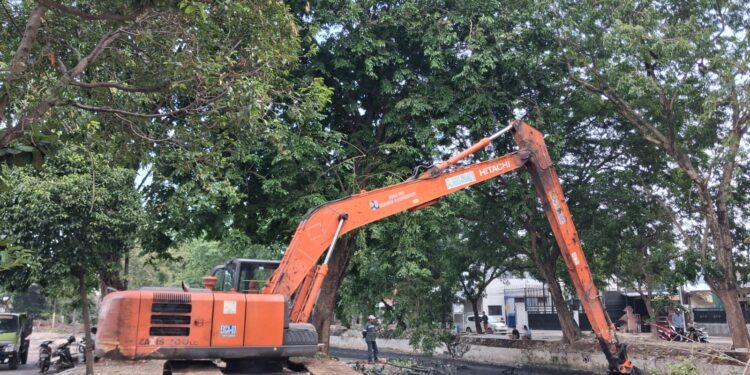 Alat berat jenis long arm saat mengeruk sedimentasi Sungai Sukalila di ruas Jalan Kalibaru.