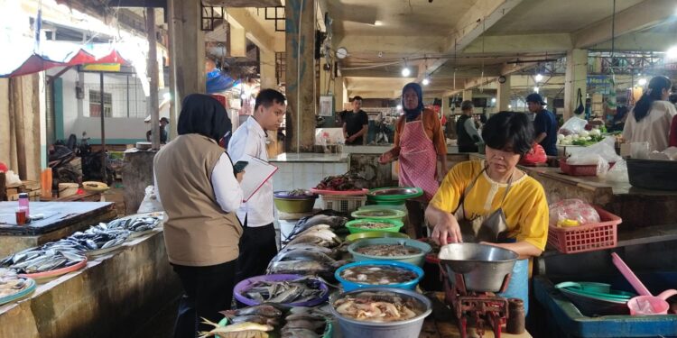 Petugas DKUKMPP Kota Cirebon saat melakukan pemantauan langsung harga kebutuhan pokok masyarakat di Pasar Kanoman.